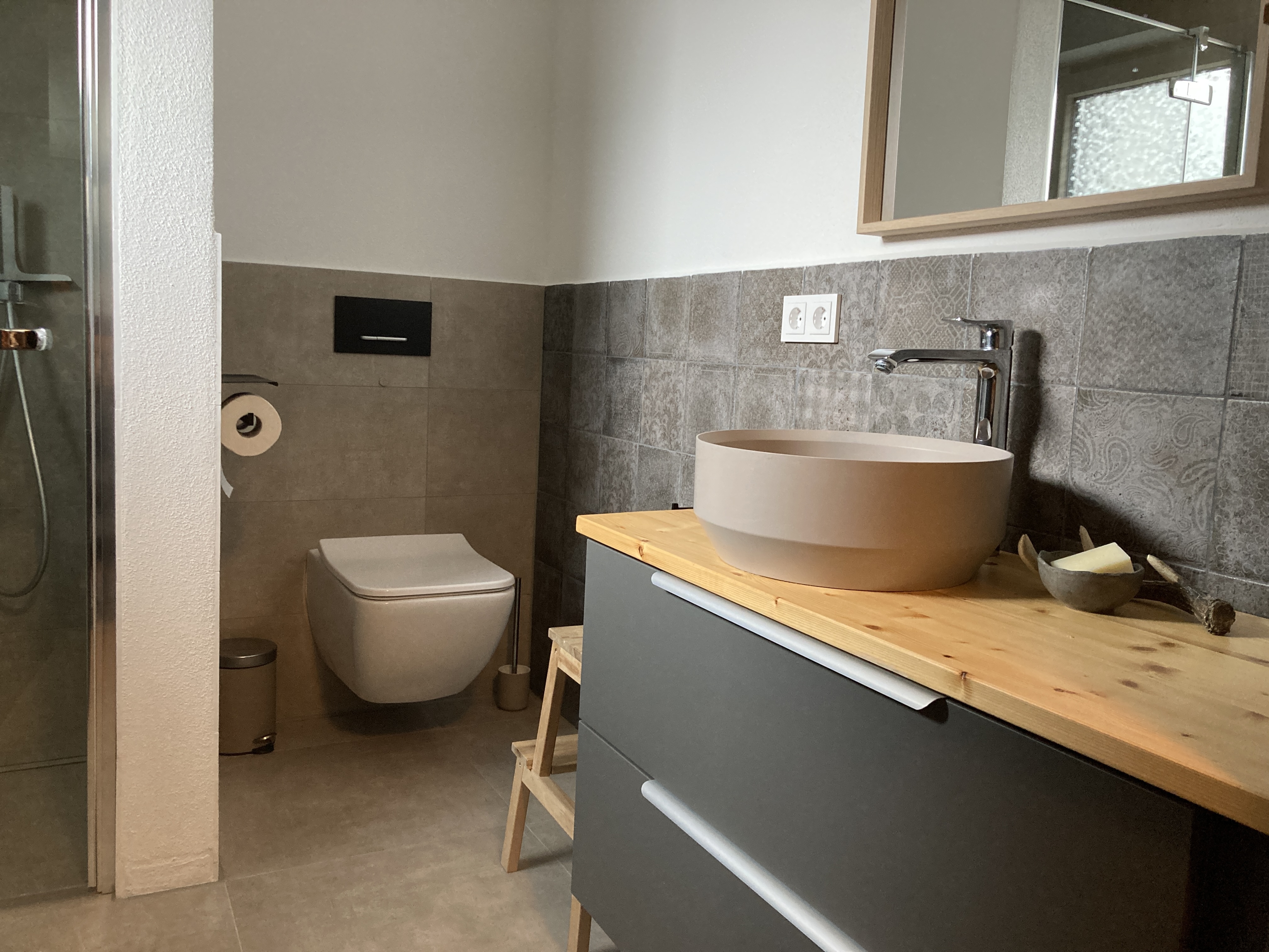 Modernes Badezimmer mit Dusche, Waschbecken und großem Spiegel